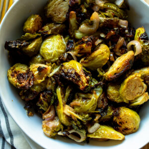 Close up of air fryer brussels sprouts with sliced shallots.
