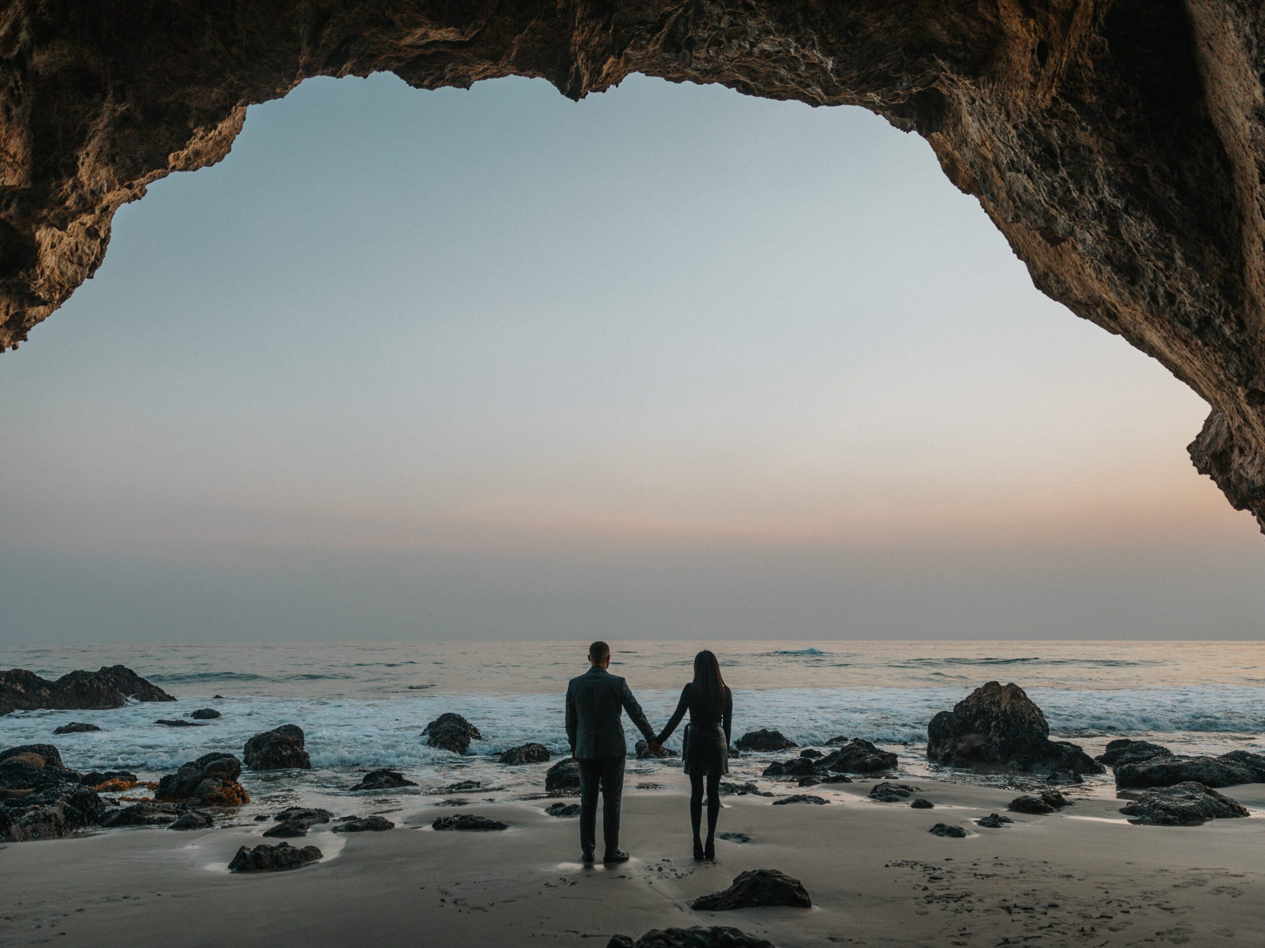 A couple holding hands on the beach.
