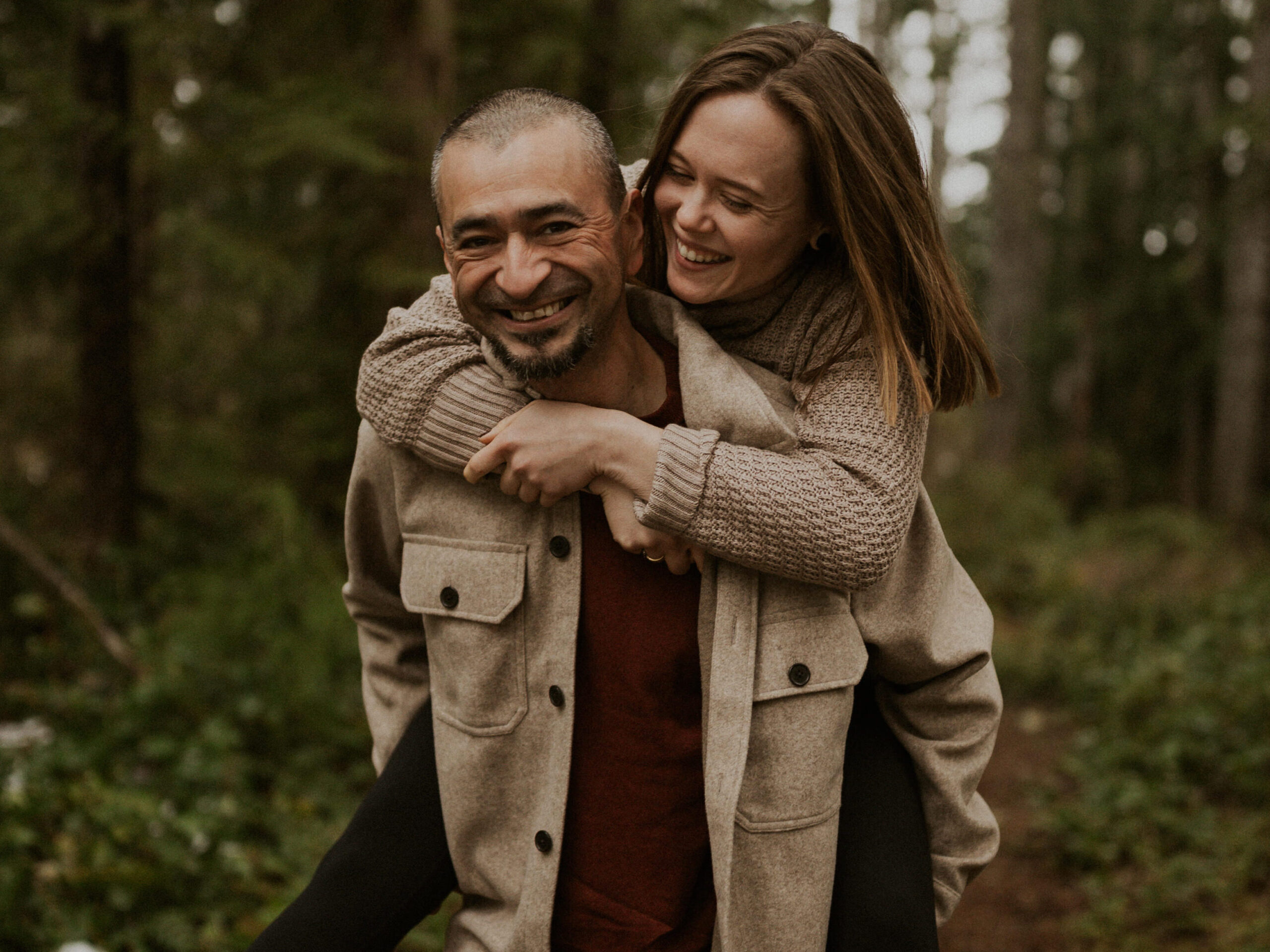 A couple embracing in the woods.
